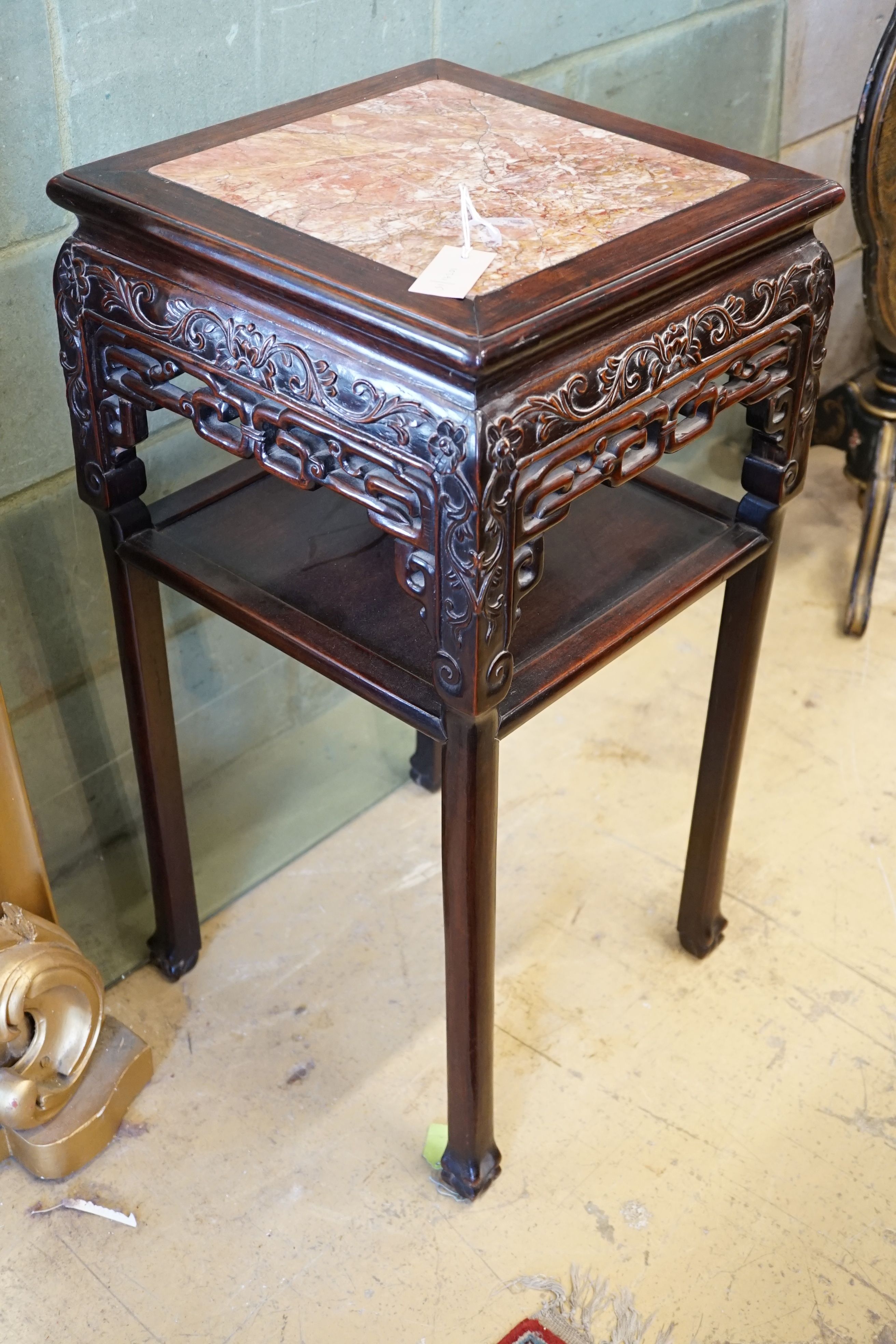 A Chinese carved hardwood rouge marble topped two tier vase stand, width 41cm, height 81cm